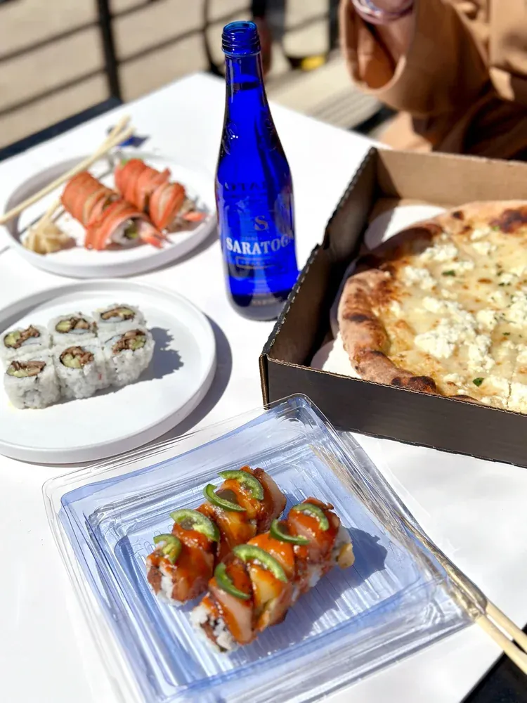 Pizza and sushi on a patio table at Pizzeria Maki